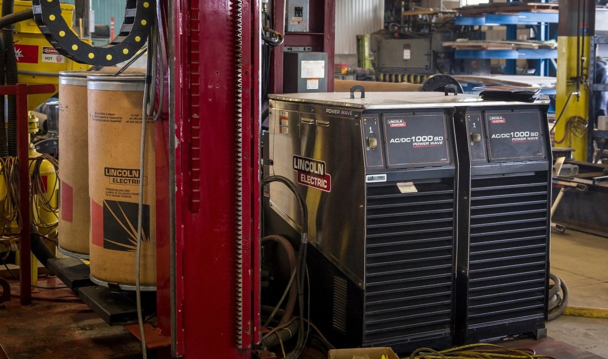 Lincoln Power Wave AC/DC 1000SD welders (U2803-1) in workshop with cables—advanced welding equipment from WeldingMart.