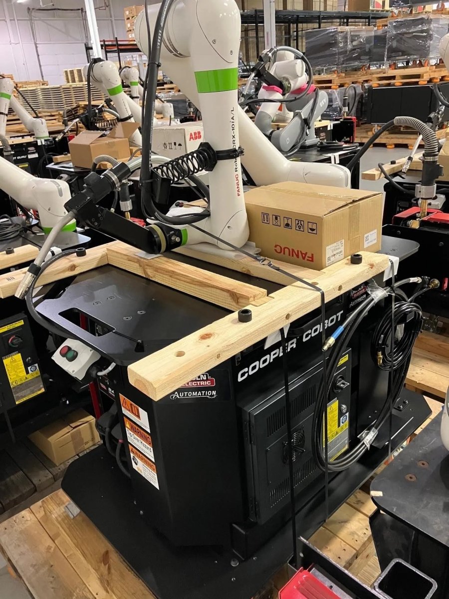 Lincoln Cooper CRX-10iA/L Air-Cooled Welding Cobot Cart AD2489-8 in warehouse, with cables, planks, and accessories on site.