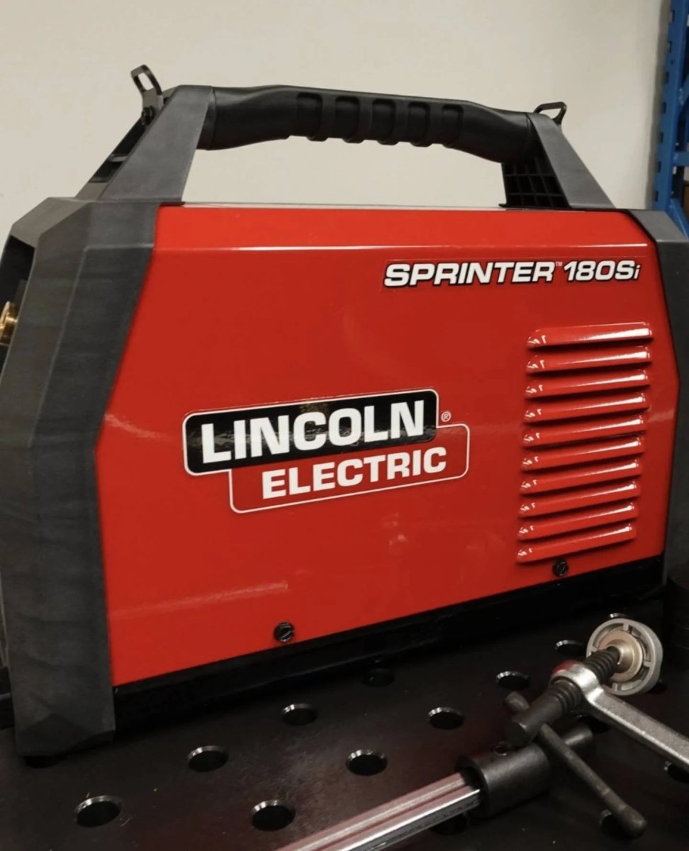 Lincoln Sprinter 180Si Factory Demo Welder U5453-1 on workbench with handles and welding tools—ideal welding equipment setup.