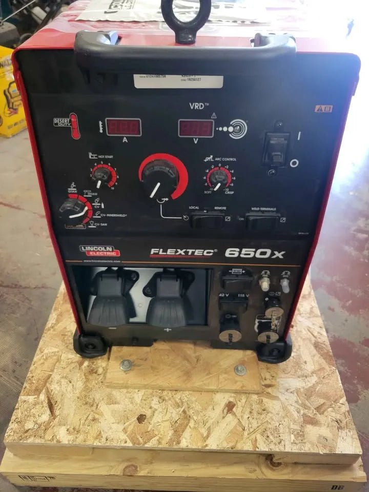 A Lincoln Flextec 650X Multi-Process Factory Demo Welder with CrossLinc Technology (U3425-1) sits on a wooden pallet, showcasing its front control panel with dials, switches, and display screens.