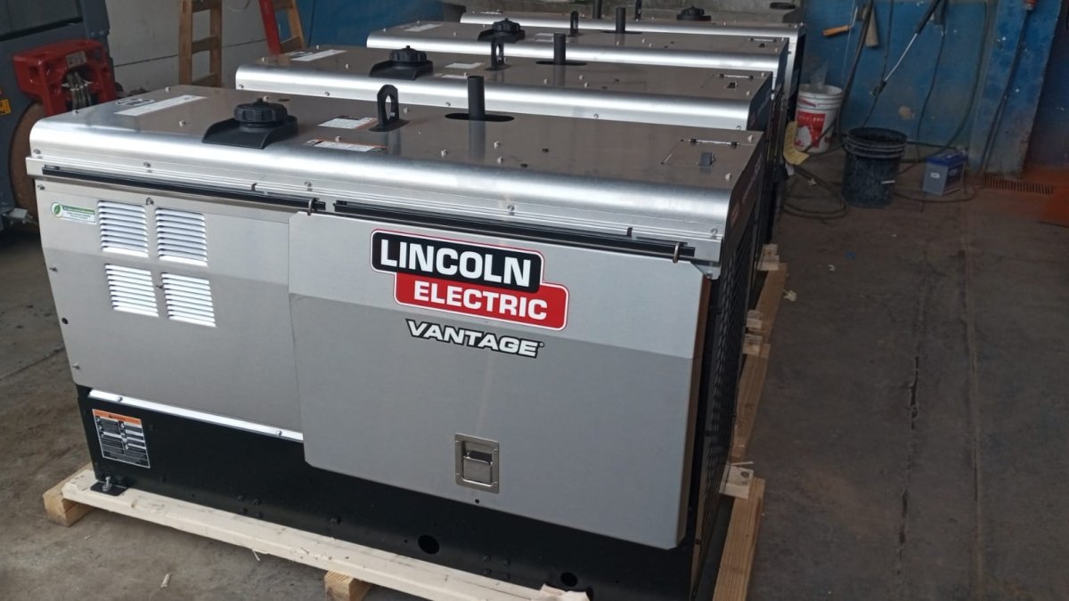 Lincoln Vantage 500 Compact Engine Driven Welders lined up on pallets indoors at WeldingMart with welding tools and accessories nearby.