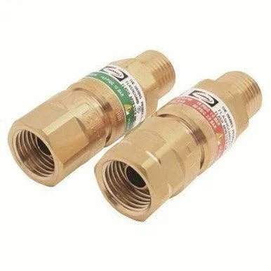 Two brass flashback arrestors, one with a green label and the other with a red label, used for gas welding and cutting equipment to prevent reverse gas flow and flashbacks.