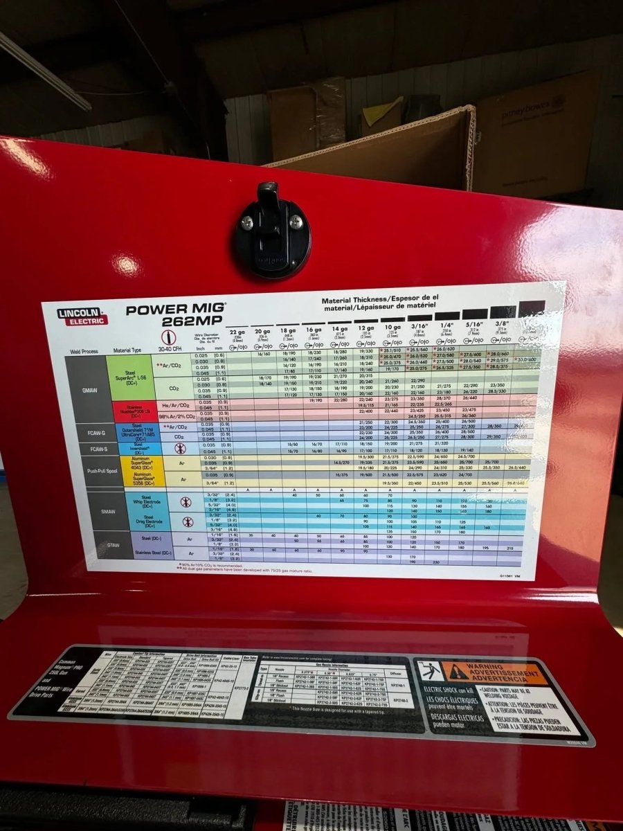 Lincoln Power MIG 262MP Welder with inside lid showing color-coded welding settings chart and specs for aluminum and other metals.