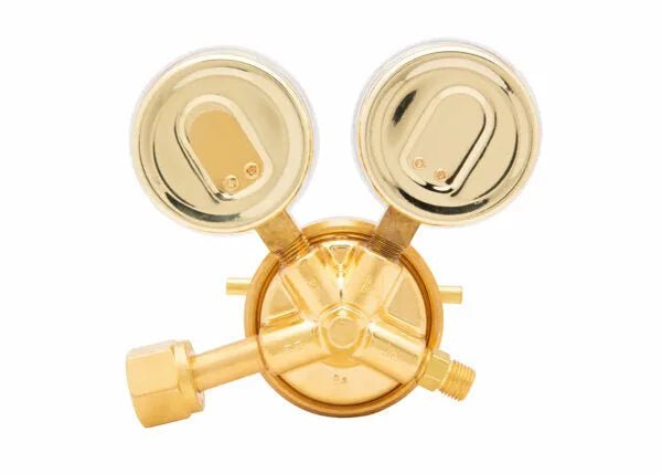A brass industrial oxygen regulator with two round pressure gauges on top is displayed against a white background.