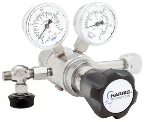 A close-up of the Harris Regulator 722C-125-326-A (722C125326A) shows two pressure gauges, a black adjustment knob, and connectors. This device accurately controls gas flow in pressurized systems.