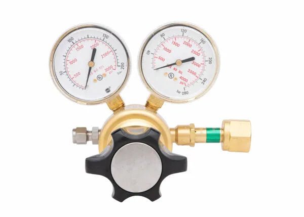 Close-up of a single stage brass regulator with two round gauges displaying pressure readings, a central black knob for adjusting, and brass and green fittings attached to the high pressure cylinder regulator assembly.