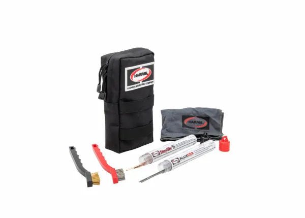 The Harris H-1000-B gun cleaning kit includes a black zippered pouch with the Hoppes logo, two cleaning rods, a small red bottle, and brushes—neatly organized like an HVAC brazing repair kit—all shown on a white background.