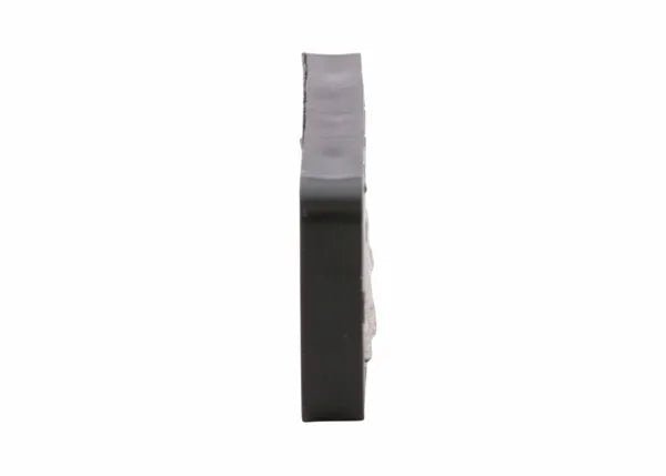 A close-up side view of a Harris Model 26-L Ignitor Renewal Flint (9004484), round and flat with a slightly uneven edge and textured, lighter surface on one side, shown against a plain white background.