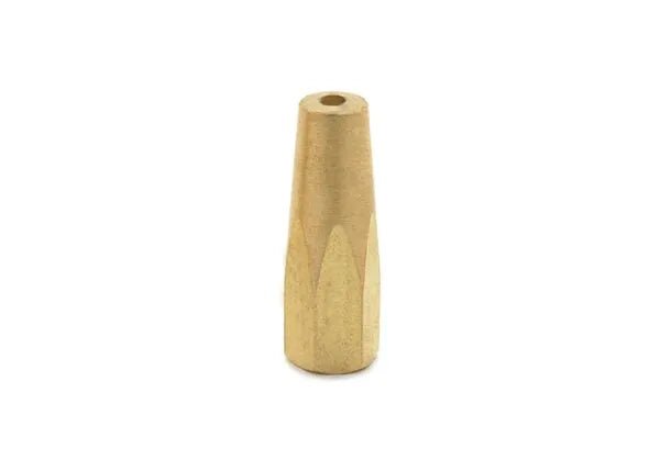 A small, cylindrical brass object resembling a Harris 8490 oxy-acetylene welding tip, with a conical shape tapering toward the top and a hole through its center, stands upright on a white background.