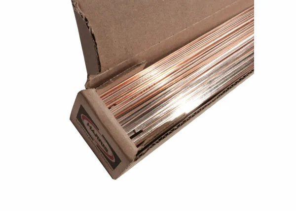 An open box of Harris Stay-Silv 15 Phos Copper Brazing Alloy (0.050 x 1/8 x 36 in., 25 lb. box - 15636F) reveals silver rods with copper tones, neatly stacked inside. The cardboard packaging is partially visible at the box edge.