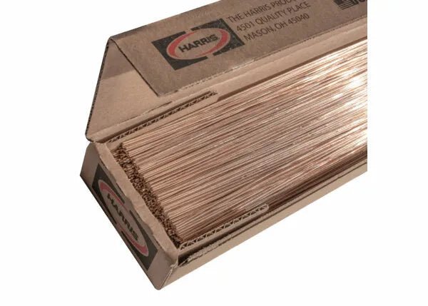 An open Harris box labeled “Stay-Silv 15 Phos-Copper Brazing Alloy 1/16 x 20 25 lb – 15320R” contains neatly stacked copper rods for HVAC and metalworking applications.