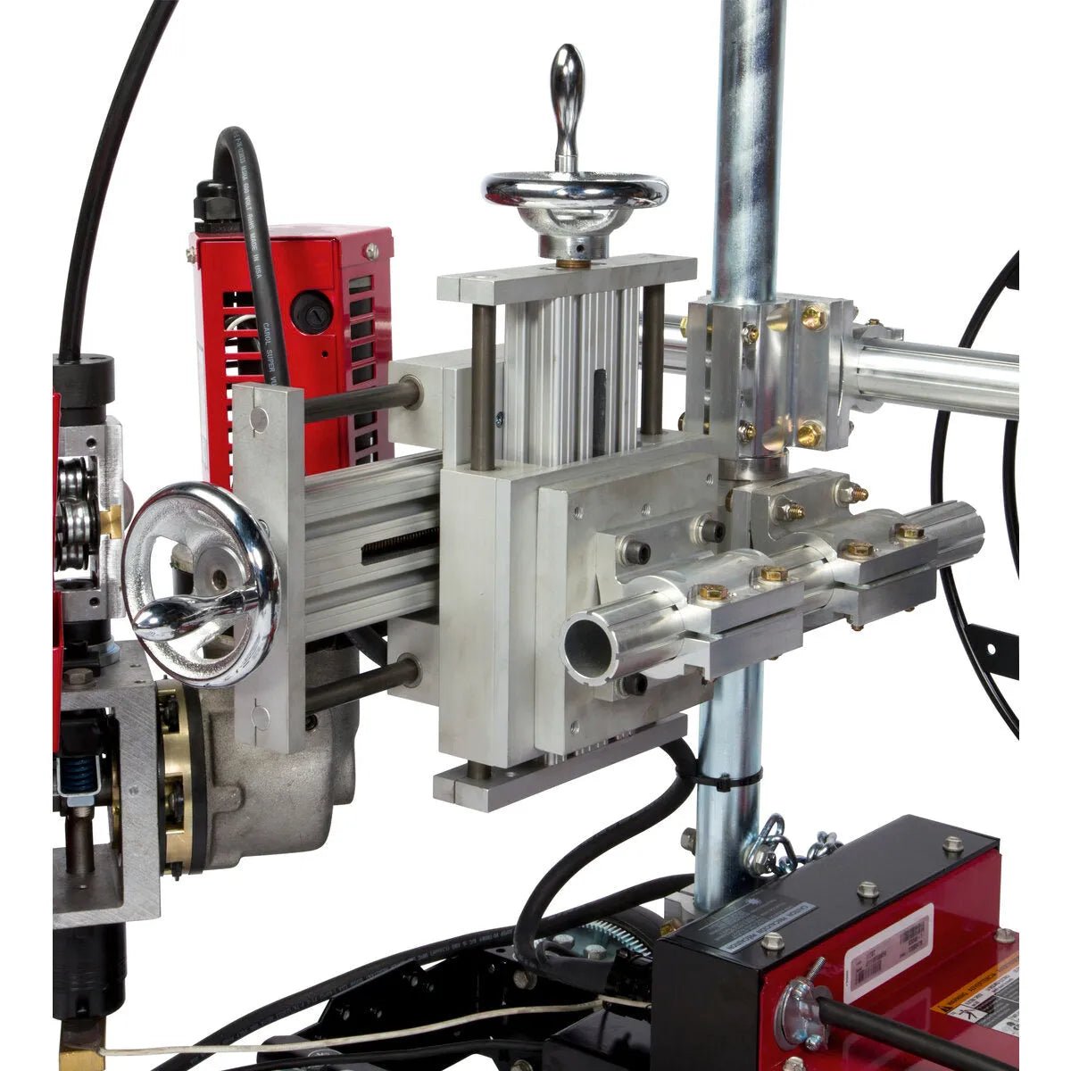 A close-up of the Lincoln Cruiser Submerged Arc Welding Tractor K3048-2 shows precision aluminum and steel parts, adjustment knobs, a red motor housing, tubing, and wiring on a sturdy frame with accessible controls.