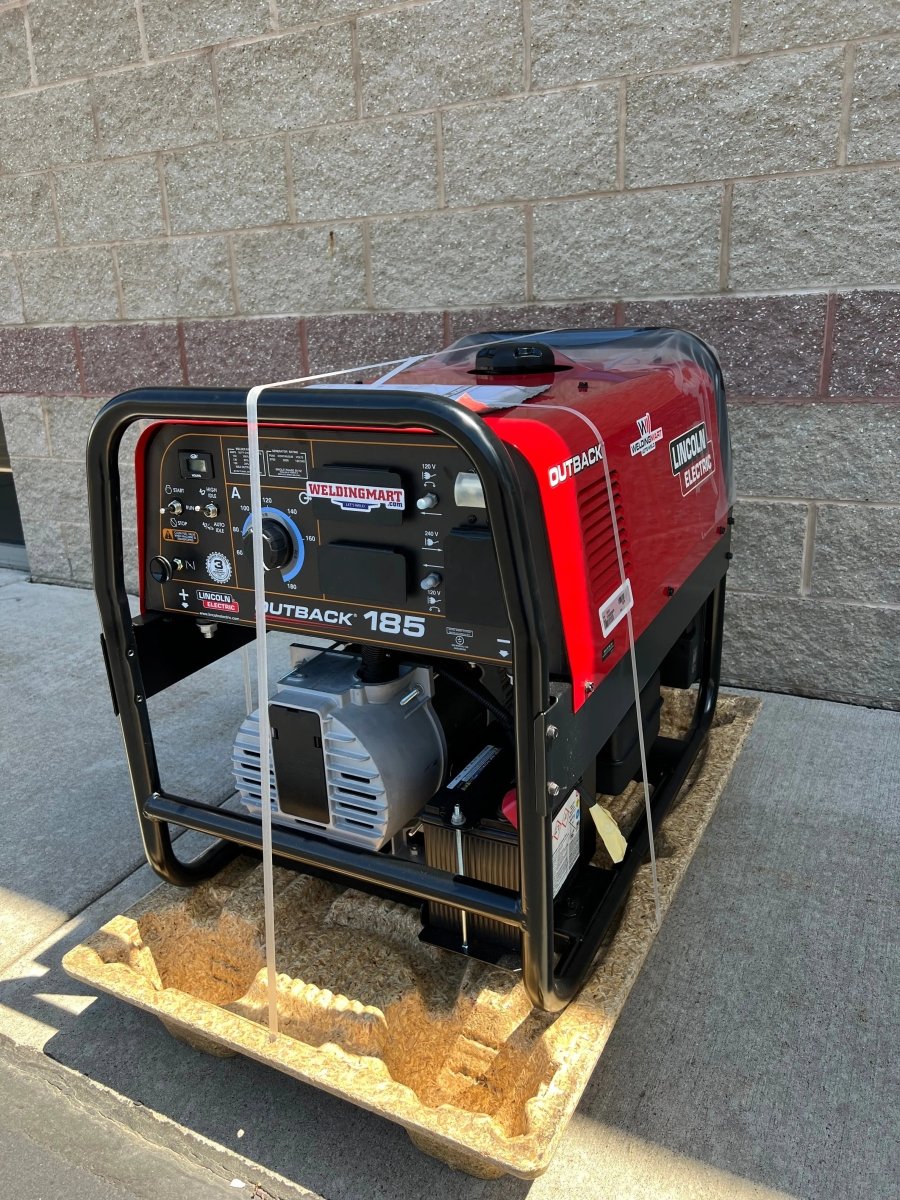 Lincoln Outback 185 Engine Driven Welder (Kohler) U2706-2, red/black, with control knobs and outlets, on cardboard by wall.