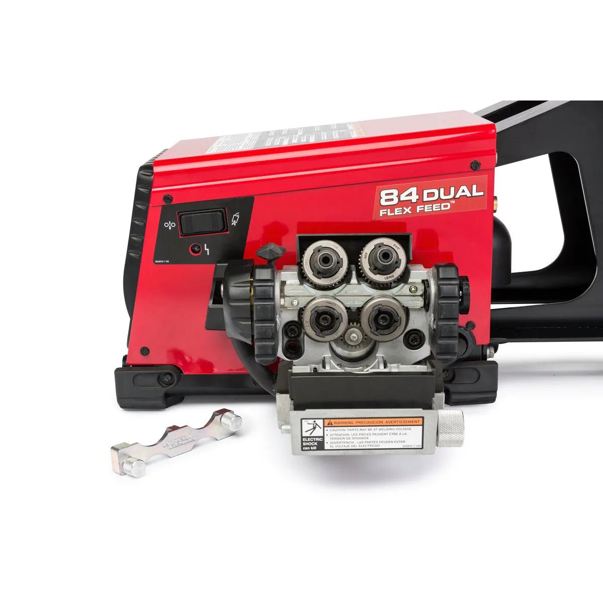 A close-up of a red Lincoln Flex Feed 84 Dual Bench with Heavy Duty Wire Reel Stand K5002-5, showing exposed feed rollers, a black handle, control switches, and a metal tool resting on the white surface beside the machine.