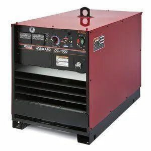 The Lincoln IDEALARC DC-1000 Multi-Process Welder Export Only (K1387-3) is a large, robust, red-and-black unit with front-panel controls and gauges, a lifting hook, and is ideal for heavy fabrication work.