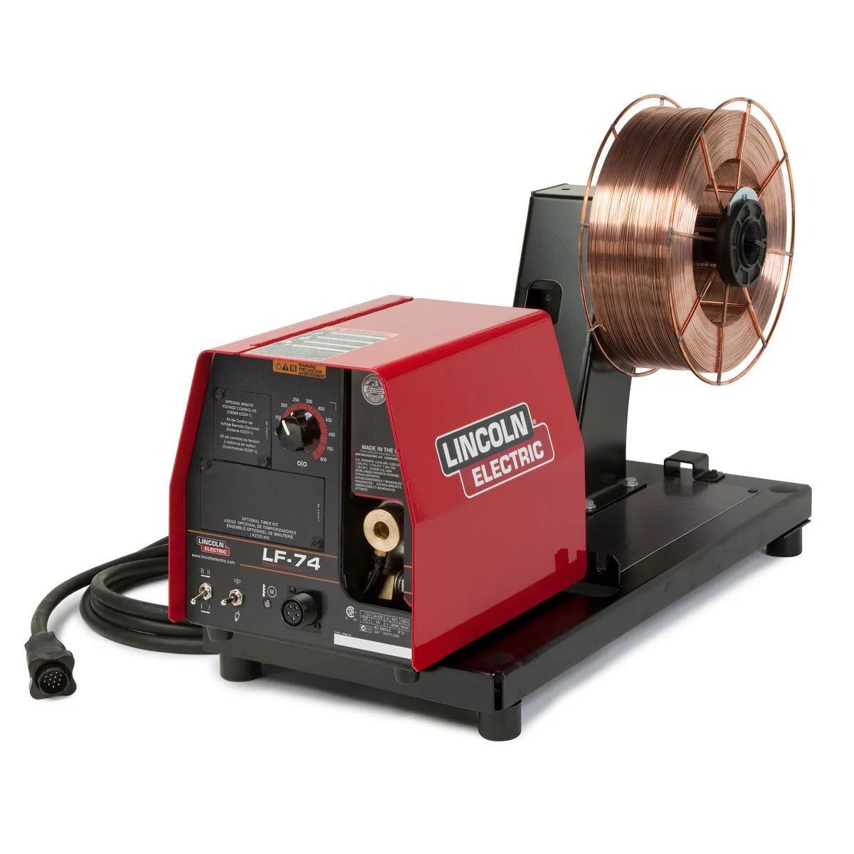 A red and black Lincoln LF-74 Wire Feeder, Bench Model Heavy Duty K2426-5, sits on a sturdy metal base with a spool of copper wire and black cable attached; brand and model are clearly marked on the front panel.