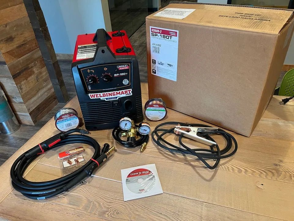 Lincoln SP-180T Wire Feeder Welder U2689-2 kit with cables, gauges, clamps, DVD & accessories on table at WeldingMart.