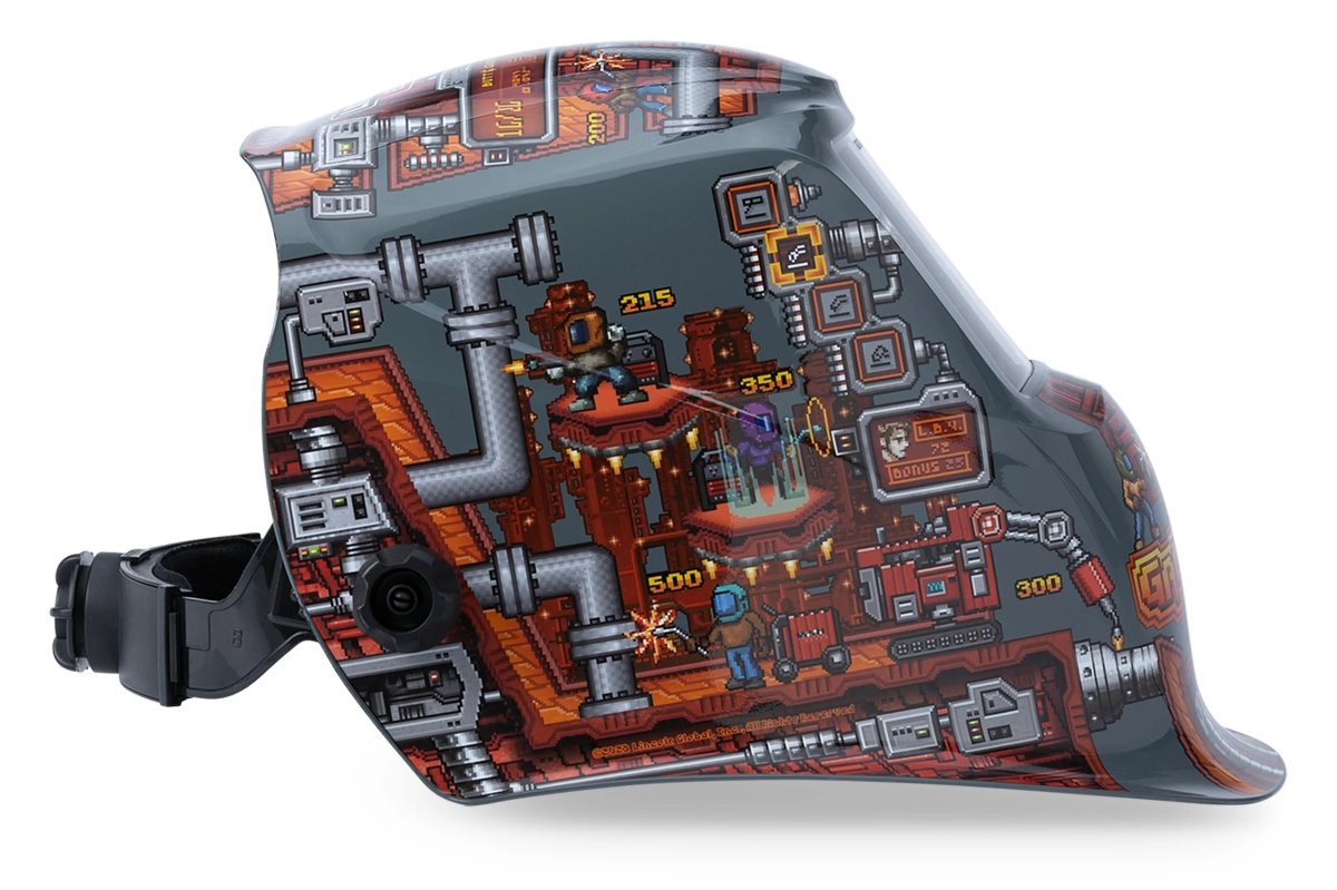 The Lincoln VIKING 1740 Game On Welding Helmet - K5562-3 features a gray shell with pixel art pipes, machines, dials, and scores. Its bold side design includes an auto-darkening lens with 4C Lens Technology for superior clarity.