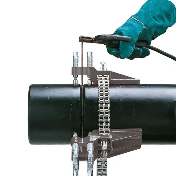 Welder in green glove using welding tool on large pipe secured by Mathey Sturdi Pipe Chain Clamp D250-SCSS from WeldingMart.