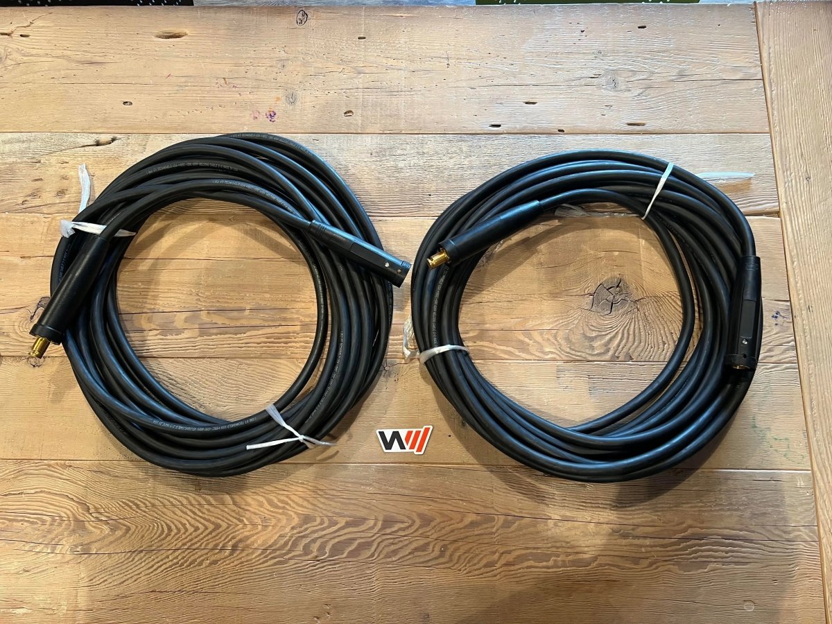 WeldingMart 50ft 2/0 welding extension leads with quick disconnect connectors, coiled and tied, on wood with WI logo.