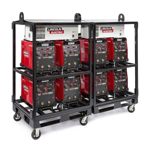 A black Lincoln inverter rack holds eight red welding machines, four per side. The rack, equipped with the Lincoln Caster Kit K2665-1, sits on six wheels. Each machine’s front panel has dials, switches, and labels.