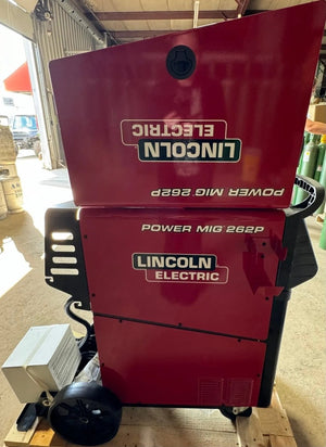 Lincoln POWER MIG 262P Welder Factory Demo U5378-1, top panel open, Lincoln logo visible, welding tools and gas tanks in background.