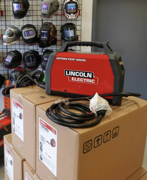 Lincoln Sprinter 180Si Factory Demo Welder U5453-1 on boxes, with welding helmets and cables at WeldingMart welding equipment store.