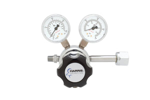 The Harris 701-125-540-C Oxygen Regulator features a stainless steel diaphragm, two pressure gauges, a black Harris Specialty Gas adjustment knob, and a metal connector. Shown against a white background.