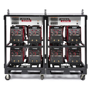 A black metal cart equipped with the Lincoln Caster Kit K2665-1 holds eight red Lincoln Electric welding machines in two rows of four, each with dials, switches, connectors, and white label signs on top for easy ID.