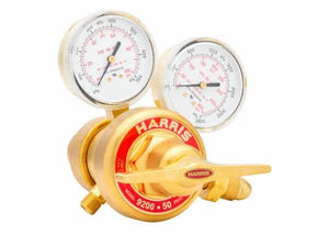 A brass Harris two stage regulator with two gauges and a red label reading HARRIS 9200 50 psi. Ideal for welding applications, the gauges display pressure measurements, and the regulator has a brass adjustment knob.