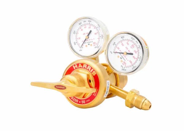 A brass two stage regulator with dual gauges and a red “HARRIS” dial, designed for precise gas control in welding applications, set against a white background.
