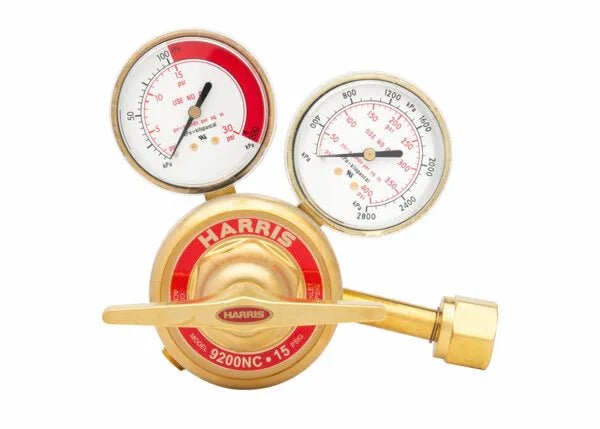 A brass Harris 9200NC two stage regulator with two pressure gauges and a control lever, ideal for welding applications. The dials display readings in psi and kPa for precise measuring and adjusting of gas pressure.