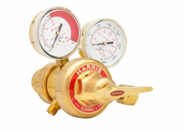 A brass Harris 9200NC two stage regulator with dual pressure gauges and a red label, designed for precise gas flow control in welding applications.