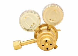 A brass acetylene regulator with two pressure gauges and a connecting pipe, viewed from above against a white background, ideal for welding applications.