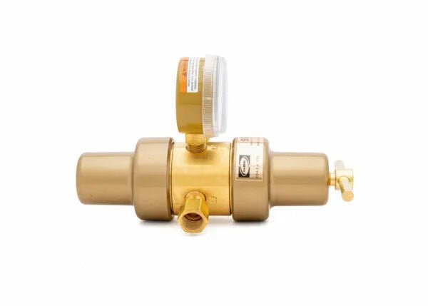A Harris 9296 brass water pressure regulator with a round pressure gauge on top and a side outlet valve, isolated on a white background, suitable for use as a two stage regulator or carbon dioxide regulator.