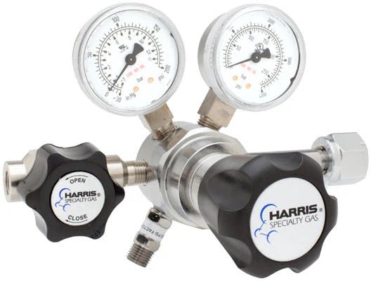 The Harris Two Stage Ultra High Purity Brass Barstock Regulator Model 721C-050-320-B features dual psi/kPa gauges, black knobs, a stainless steel diaphragm, and multiple ports for precise flow in ultra high purity applications.