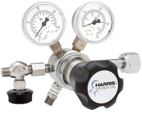 Close-up of a Harris Two Stage Ultra High Purity Brass Barstock Regulator Model 721C-050-326-A, featuring two pressure gauges, a black Harris logo knob, and metal fittings for precise gas flow and pressure control.