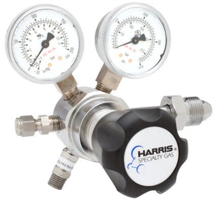The Harris Two Stage Ultra High Purity Brass Barstock Regulator Model 721C-050-580-F features dual pressure gauges (psi/kPa), the HARRIS SPECIALTY GAS logo on the knob, and multiple threaded connectors for precise gas flow control.