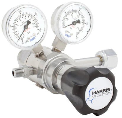 The Harris 742-125-350-B regulator features stainless steel construction, dual round pressure gauges with clear numeric markings, a large black Harris Specialty Gas knob, multiple ports, and precise gas flow control for Cl2/CO/Propane/H2.