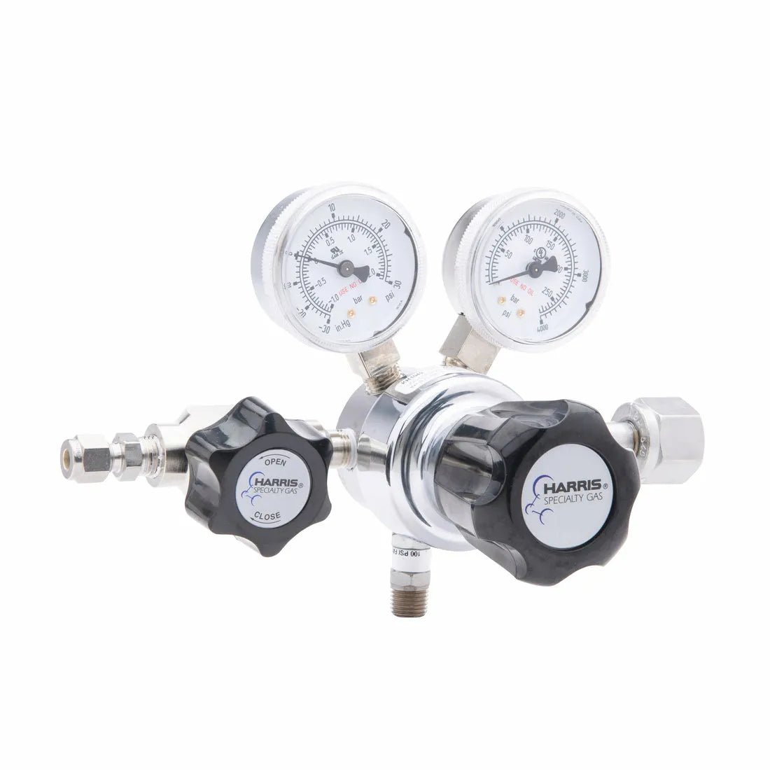 The Harris 701-015-540-BE Oxygen Regulator is a silver single stage cylinder regulator with dual pressure gauges, two black knobs, and multiple connectors for gas cylinders or tubing, labeled Harris Specialty Gas.