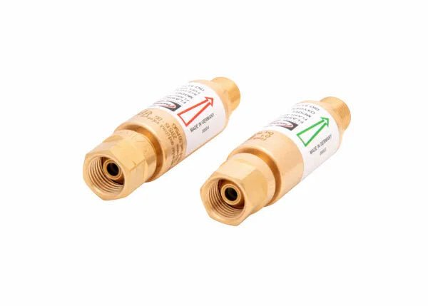Two regulator-type flashguard brass flashback arrestors with hexagonal ends, each labeled with directional arrows—one red and one green—for safe oxygen and fuel gas flow direction in gas welding or cutting applications.