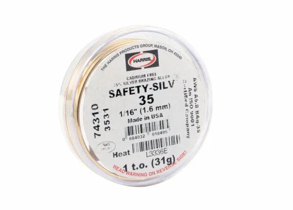 A Harris 3531 Safety-Silv® 35 high silver brazing alloy spool, 1/16 in., 1 toz. cup, is made in the USA, cadmium-free, with barcode and safety warnings on the label; filler metal visible through its clear lid.