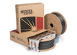 Two large spools of Flux-Cored welding wire, one partially unwrapped, are shown next to two cardboard Lincoln Electric boxes. The boxes have branding and a graphic with red, black, and beige colors—ideal for seismic structural fabrication.
