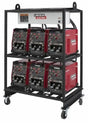 A metal wheeled rack holds six Lincoln 6-PACK RACK FLEXTEC 500 MULTI-PROCESS WELDER K4099-1 units in two rows of three, each with control dials, digital displays, and a white label with the Lincoln Electric logo—ideal for fabrication shops.
