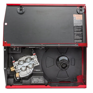 A close-up of a red welding machines interior shows the wire-feeding system on the left and a large black spool holder on the right. The open lid displays safety instructions, two black latches, and a Lincoln APEX 30M Mechanized Controller K52160-1.