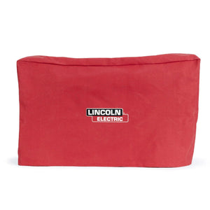 The Lincoln CanVAS Cover (Small-Medium) K2377-2 is a red, flame-retardant rectangular canvas welder cover with the Lincoln Electric logo in black, white, and red at the center, shown slightly wrinkled against a plain white background.