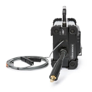 The Lincoln CrossLinc Remote K4345-1, a compact black welding machine, is shown from the back with a welding cable and clamp plugged in, wire coiled nearby. It has welder remote ports for easy output control and a top handle.