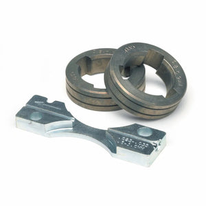 Two circular steel threading dies, each with an inner cutout and etched markings, are positioned behind a metal die stock holder with two screw holes—similar in precision to a Lincoln Drive Roll Kit or wire guide—against a white background.
