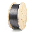 A large wooden spool is tightly wound with Lincoln ED012163 Innershield NR-131 flux-cored FCAW-S welding wire, 3/32 in, 600 lb speed feed reel, its flat wooden sides showing visible grain and screw holes as the dark gray wire is neatly coiled.