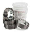 Several coils of Lincoln ED012438 Innershield NR-207 Flux-Cored FCAW-S Welding Wire, 5/64 in, (4) 14 lb Coil, are stacked before a large white bucket. The wire is tagged for API Pipe Grades X42-X70 and pipeline welding use.